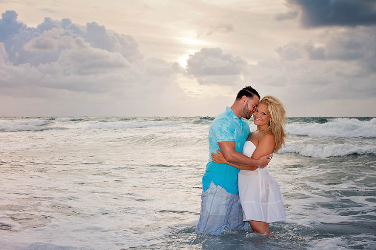 An Engaged Couple Stand in the Surf